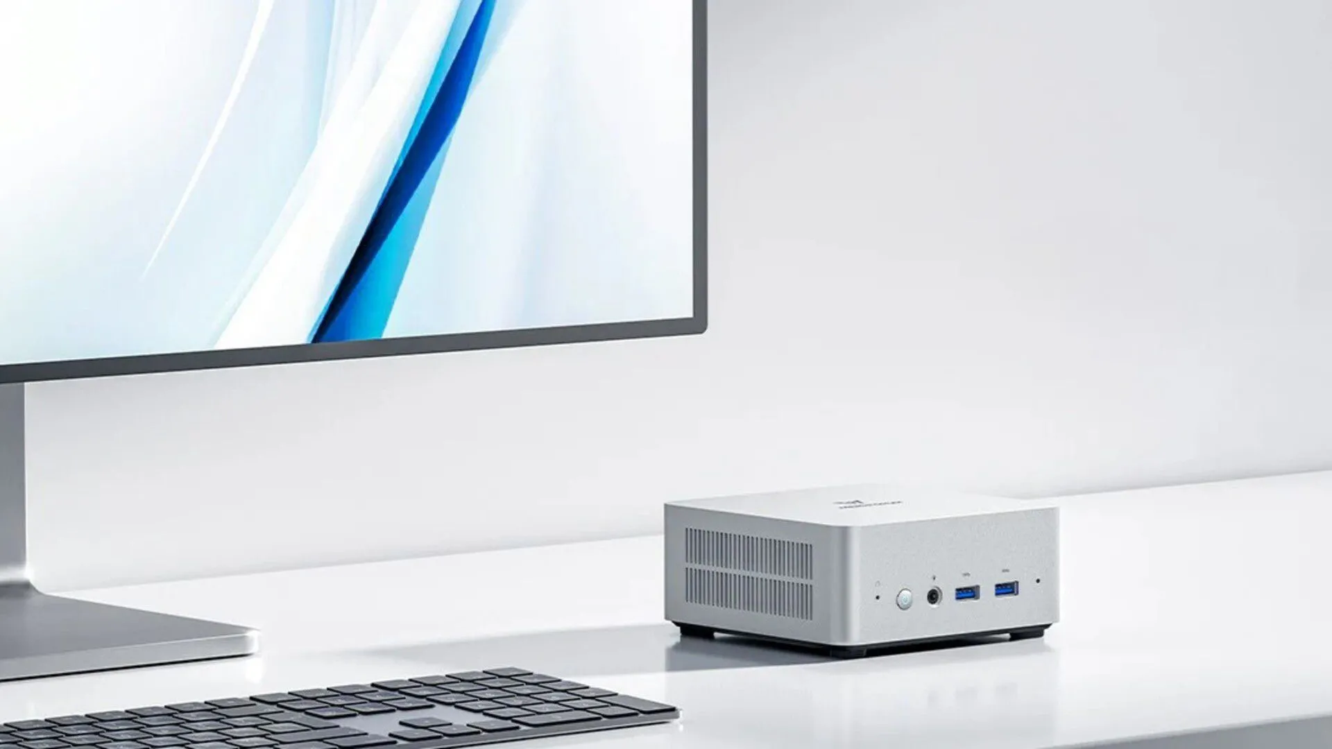 Mini PC MINISFORUM UN1250 màu đen đặt trên bàn cạnh cây xanh.