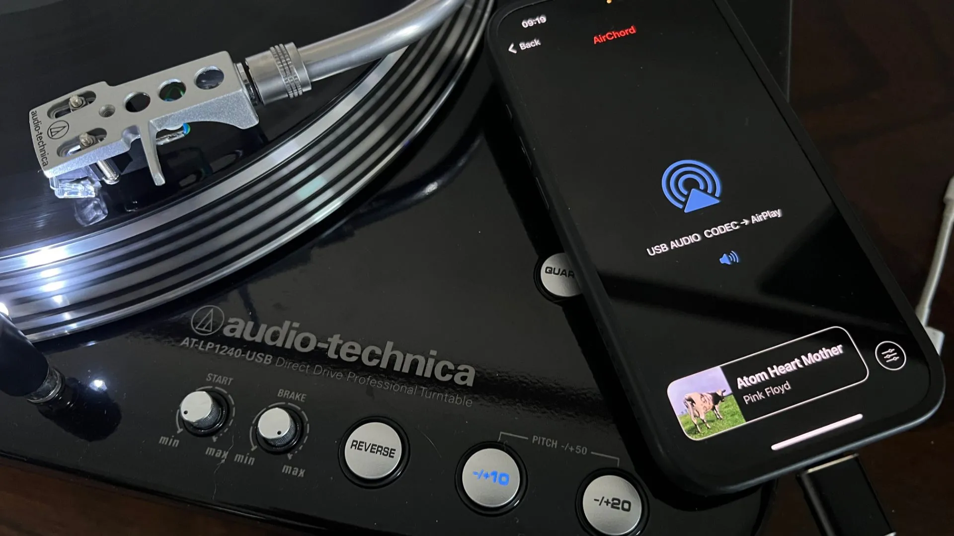 Một chiếc iPhone đang chạy ứng dụng AirChord 2, kết nối với mâm đĩa than và phát nhạc qua AirPlay.