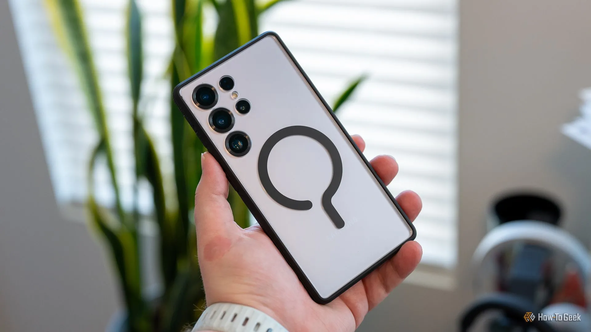 Người dùng đang cầm chiếc Samsung Galaxy S25 Ultra được bảo vệ bởi ốp lưng dbrand Ghost 2.0 trong suốt.