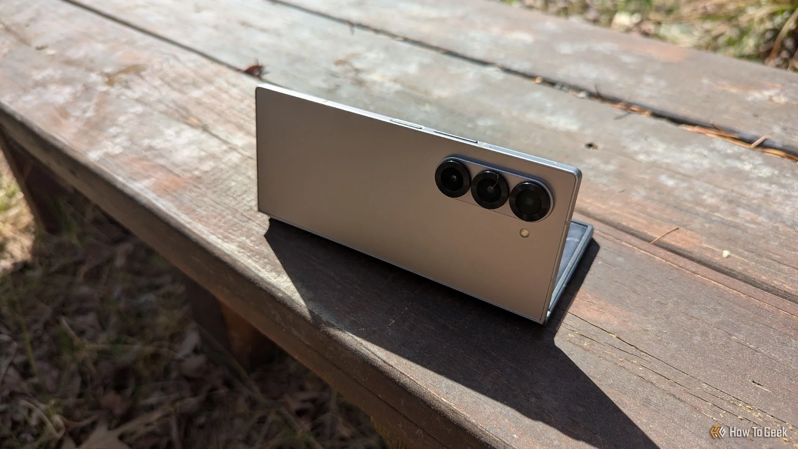 Điện thoại Samsung Galaxy Z Fold 6 đặt trên ghế dài, tự đứng vững như một tripod để chụp ảnh hoặc xem video