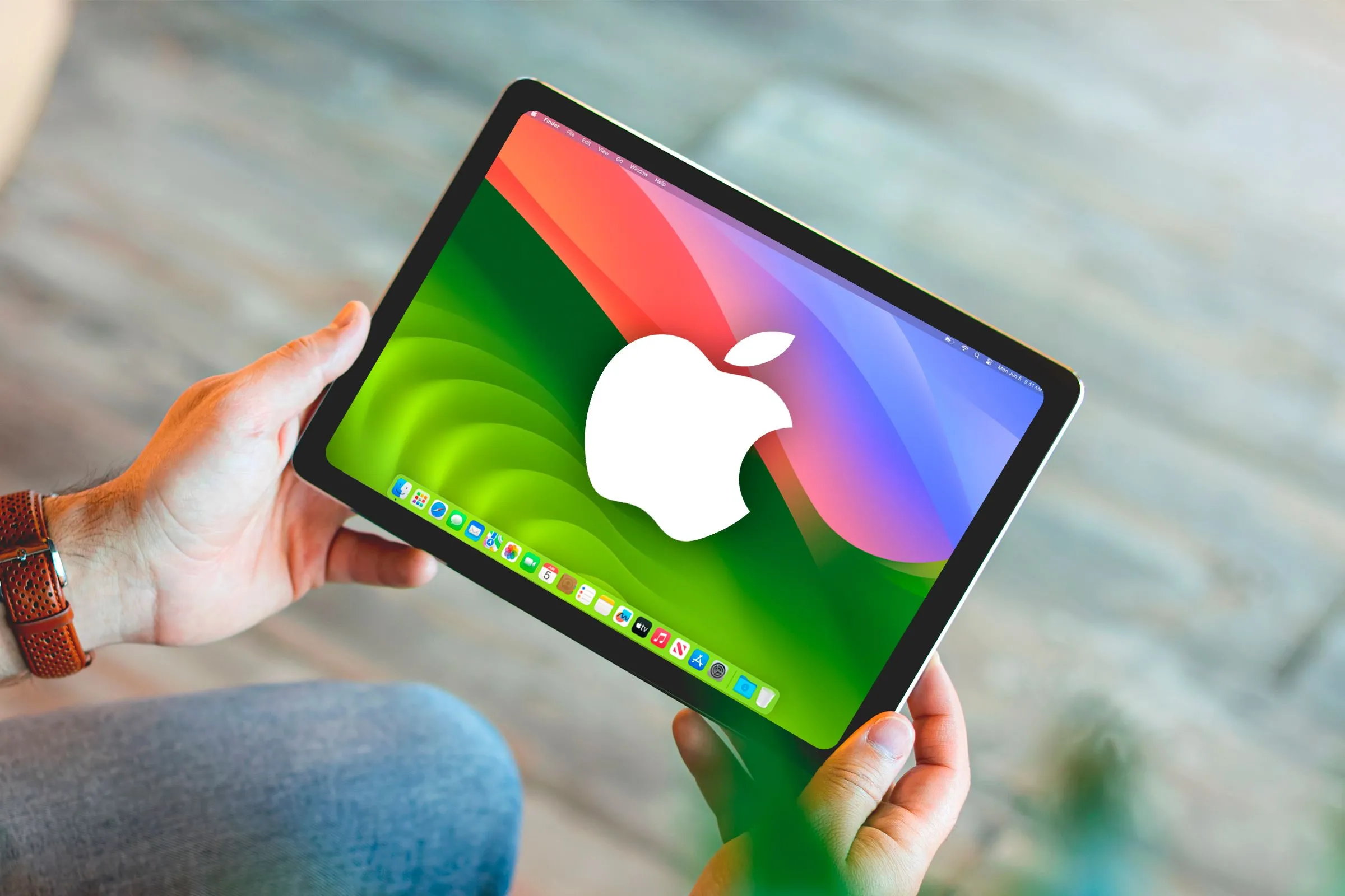 Hình ảnh minh họa một bàn tay cầm iPad với giao diện giả lập macOS và logo Apple, thể hiện ước muốn về khả năng này.