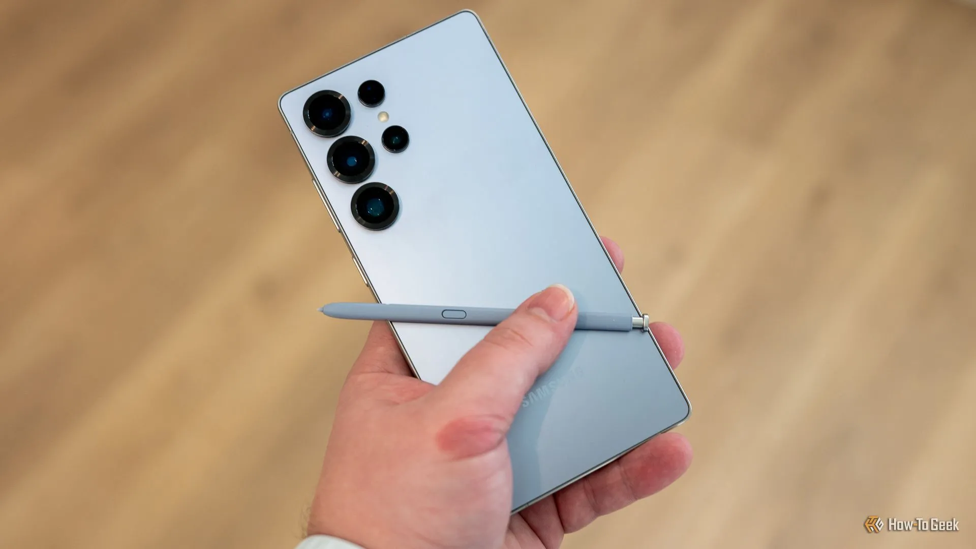 Người dùng cầm Samsung Galaxy S25 Ultra trên tay, cho thấy mặt lưng điện thoại và bút S Pen