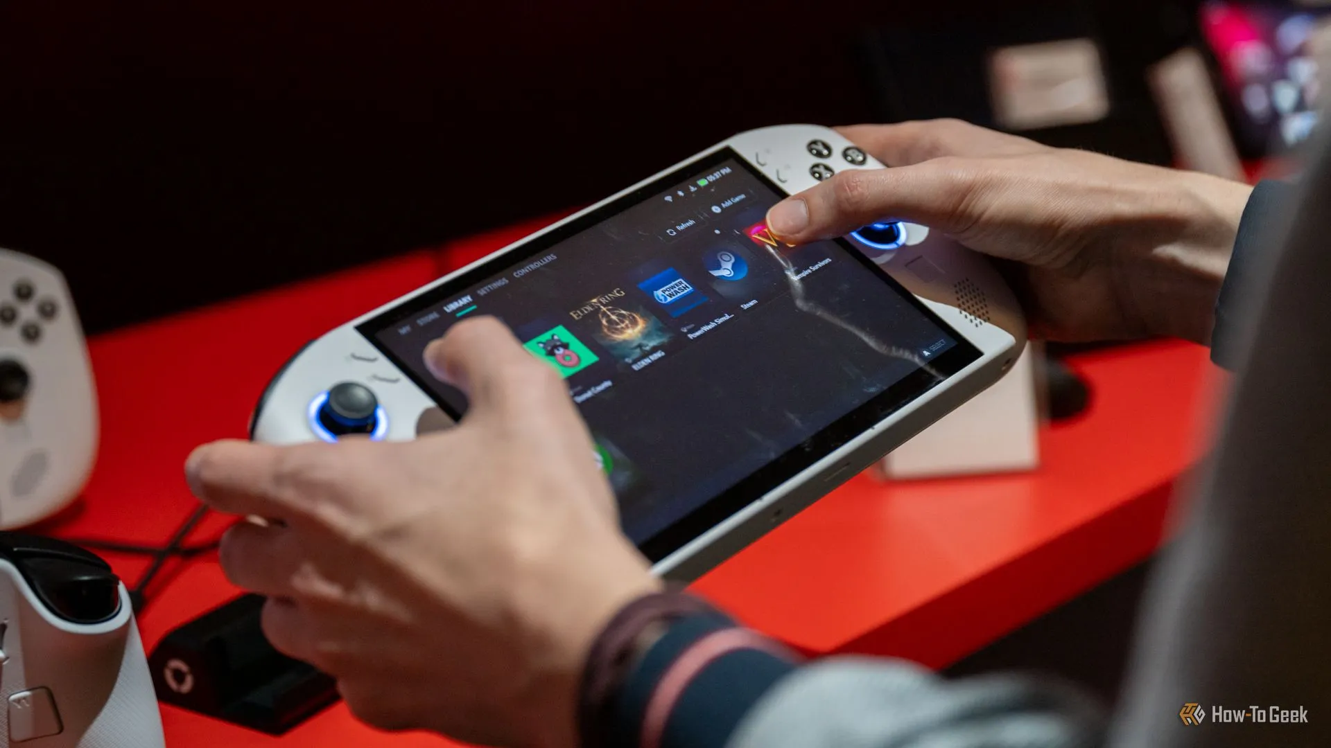 Người dùng tương tác với màn hình chính của máy chơi game cầm tay Lenovo Legion Go S 8 inch, cho thấy kích thước lớn và khó thao tác.